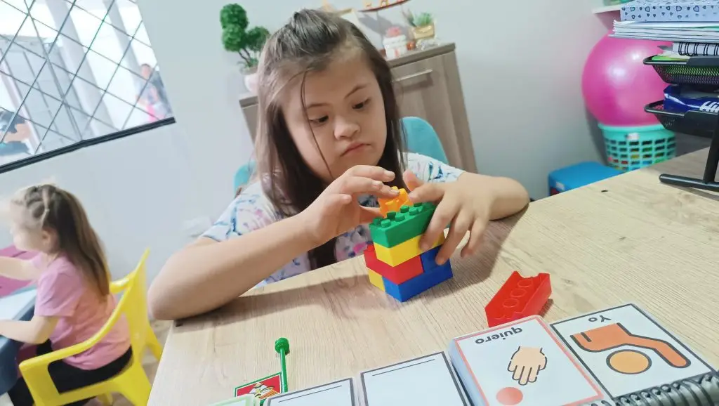 niña down jugando con legos